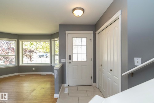 Entryway featuring a white paneled door with glass inserts, light tile flooring, and a flush mount ceiling light - 137 Michigan Street, Devon, AB 