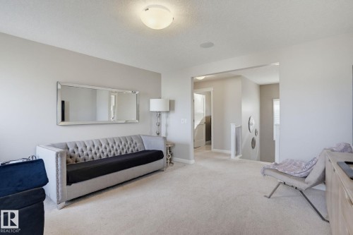 Carpeted room with light neutral wall tones, recessed lighting, and a wide entryway - 9448 228 Street Nw, Edmonton, AB 