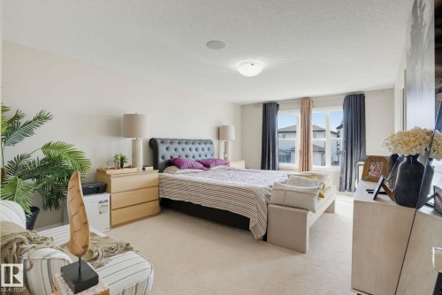 Expansive room with carpet flooring, a large window, recessed ceiling speaker, and a built-in flush mount ceiling light - 9448 228 Street Nw, Edmonton, AB 