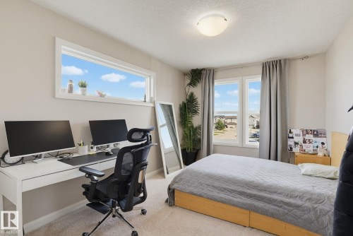 Neutral wall paint, carpeted flooring, a flush mount ceiling light, and white trim around windows - 9448 228 Street Nw, Edmonton, AB 