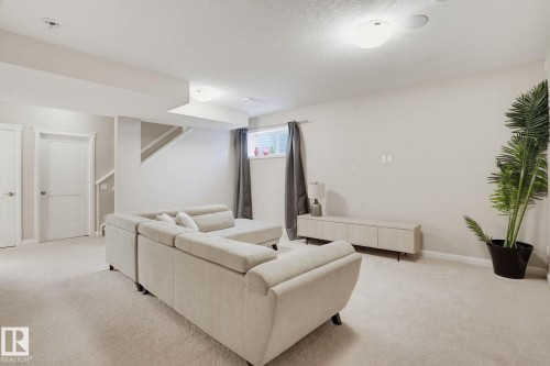 Carpeted flooring, recessed lighting, white trim, and a built-in media cabinet - 9448 228 Street Nw, Edmonton, AB 