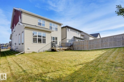 Expansive backyard featuring a wood privacy fence, a multi-level deck, and light-colored siding - 9448 228 Street Nw, Edmonton, AB 