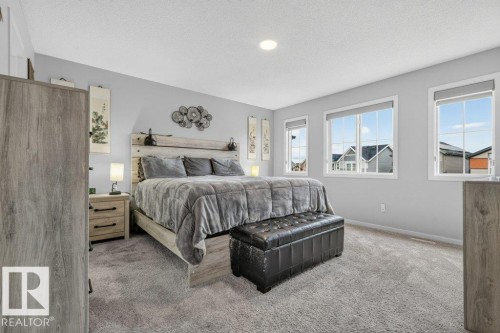 Carpeted flooring, recessed ceiling lighting, three windows with white trim, and light gray wall paint - 1020 Daniels Loop Sw, Edmonton, AB 