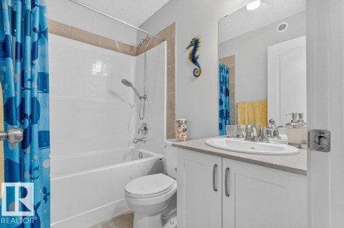 White vanity with a built-in sink, gray countertop, chrome faucet, and white cabinetry - 1020 Daniels Loop Sw, Edmonton, AB 