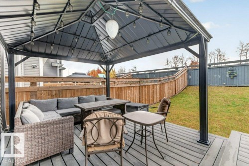 Wood-finish deck with a built-in gazebo, featuring string lighting and a central fixture - 1020 Daniels Loop Sw, Edmonton, AB 
