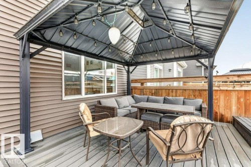 Covered outdoor deck with a metal gazebo structure, string lighting, and wood-finish flooring - 1020 Daniels Loop Sw, Edmonton, AB 