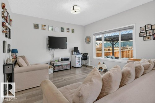Light gray walls, light wood-finish flooring, and a large multi-pane window - 1020 Daniels Loop Sw, Edmonton, AB 