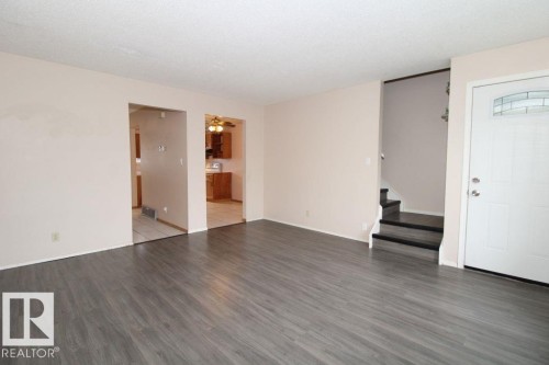 Bathroom vanity with wood-finish cabinetry, integrated sink, and brushed metal faucet - 11393 22 Avenue Nw, Edmonton, AB 