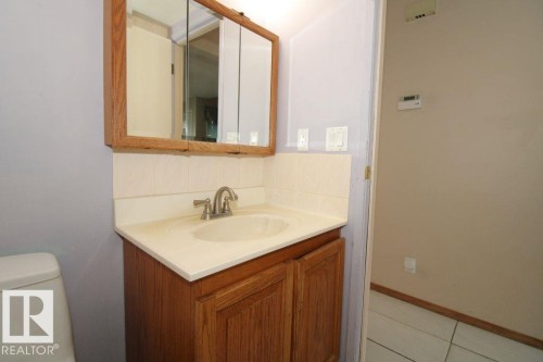 Hallway with wood-finish flooring, flush mount lighting, and white interior doors - 11393 22 Avenue Nw, Edmonton, AB 