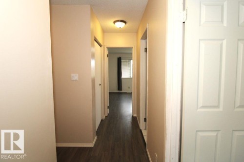 Spacious room featuring wood-finish flooring, light-toned walls, and a window with blinds - 11393 22 Avenue Nw, Edmonton, AB 
