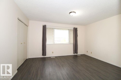 Wood-finish flooring, ceiling-mounted light fixture, and closet with bi-fold doors - 11393 22 Avenue Nw, Edmonton, AB 