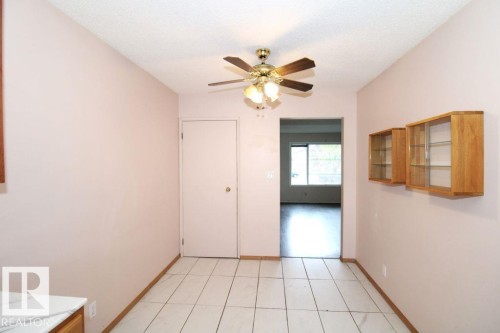 Tile flooring, ceiling fan with integrated lighting, built-in display cabinets with glass doors, and a neutral wall color - 11393 22 Avenue Nw, Edmonton, AB 