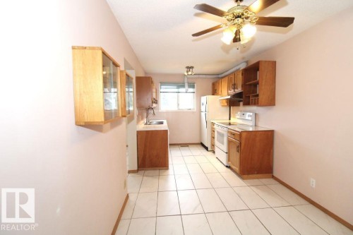 Spacious room featuring wood-finish flooring, neutral-toned walls, and a large window with white trim - 11393 22 Avenue Nw, Edmonton, AB 