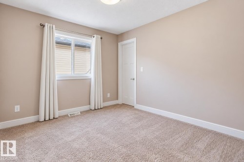 Neutral-toned walls, plush carpet flooring, and a single window with white trim - 258 Albany Drive Nw, Edmonton, AB 