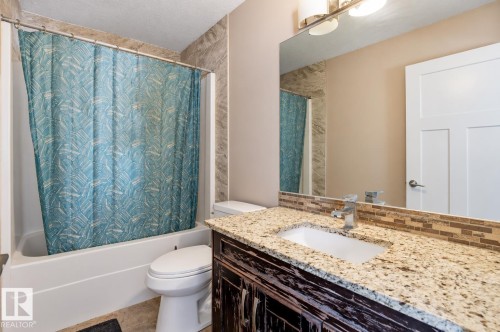 Bathroom featuring a tub/shower combination, vanity with a light-toned countertop, and a tiled backsplash - 258 Albany Drive Nw, Edmonton, AB 