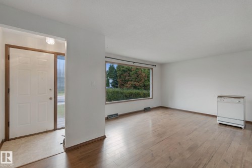 Wood-finish flooring, white walls, and a large window providing natural illumination - 8424 70 Street Nw, Edmonton, AB 