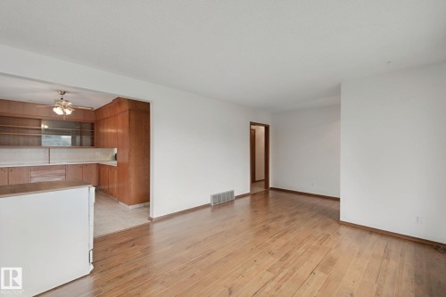 Hardwood flooring throughout, white wall paint, and wood-finish cabinetry - 8424 70 Street Nw, Edmonton, AB 