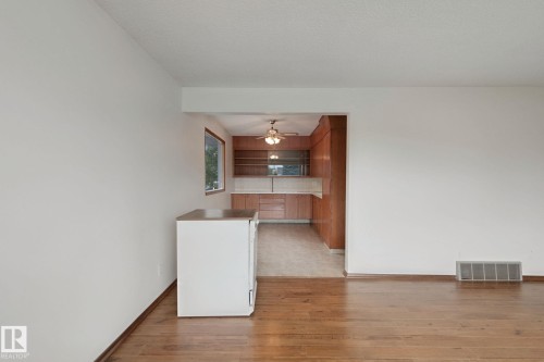 Hardwood flooring, wood-finish cabinetry, built-in shelving, and a ceiling fan - 8424 70 Street Nw, Edmonton, AB 
