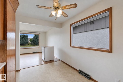 Neutral tone wall finishes, ceiling fan with light kit, wood-finish window trim, and wood-finish flooring - 8424 70 Street Nw, Edmonton, AB 