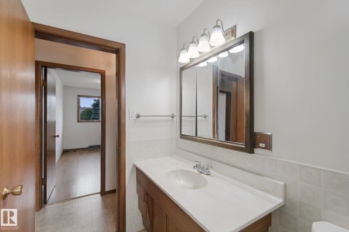 Wood-finish vanity with a white countertop and integrated sink - 8424 70 Street Nw, Edmonton, AB 