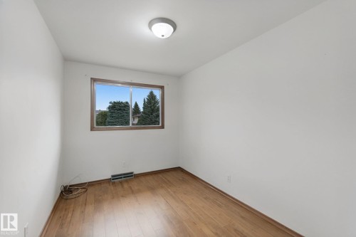 Wood-finish flooring with a window featuring exterior scenery - 8424 70 Street Nw, Edmonton, AB 