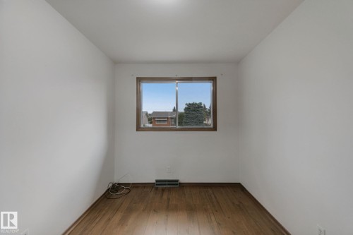 Hardwood flooring, painted walls, and a window with wood-finish trim - 8424 70 Street Nw, Edmonton, AB 