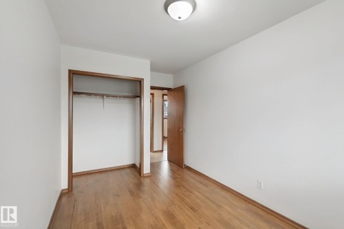 Wood-finish flooring, white walls, and a ceiling-mounted light fixture - 8424 70 Street Nw, Edmonton, AB 