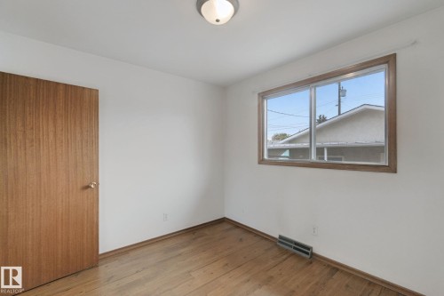 Wood-finish flooring with white walls, wood-framed window, and flush mount lighting - 8424 70 Street Nw, Edmonton, AB 