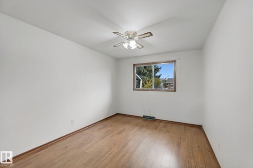 Wood-finish flooring, white walls, and a ceiling fan with integrated lighting - 8424 70 Street Nw, Edmonton, AB 