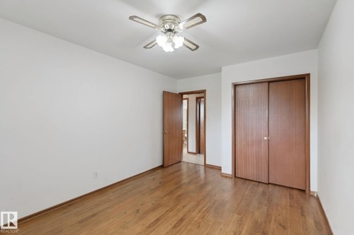Wood-finish flooring throughout, white walls, and a ceiling fan with integrated lighting - 8424 70 Street Nw, Edmonton, AB 