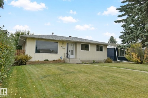 Ranch-style exterior with a large front picture window, a covered entry, and a side extension with multiple windows - 8424 70 Street Nw, Edmonton, AB 