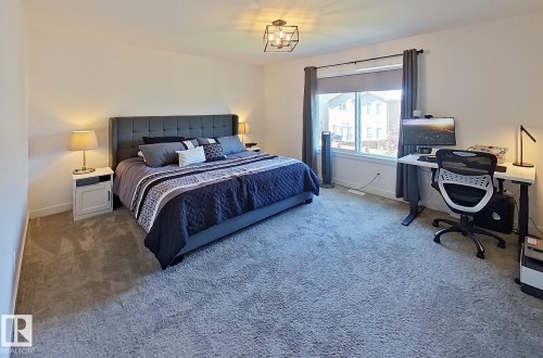 Carpeted room with a large window, a ceiling-mounted light fixture, and an upholstered headboard - 40 Jamison Crescent, St. Albert, AB 