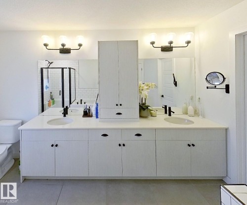 Double vanity with integrated sinks, white cabinetry, and matte black fixtures - 40 Jamison Crescent, St. Albert, AB 