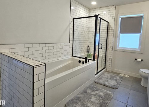 Subway tile surround, built-in bathtub, glass-enclosed shower, and tiled flooring - 40 Jamison Crescent, St. Albert, AB 
