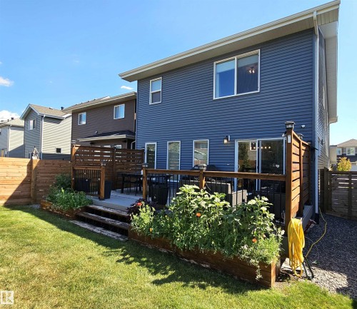 Expansive backyard featuring a manicured lawn, multi-level wood deck, and built-in planters - 40 Jamison Crescent, St. Albert, AB 