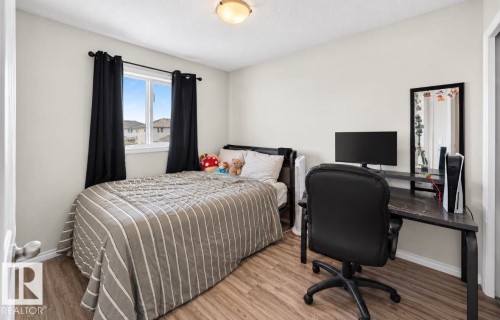 Wood-finish flooring, single window, flush mount ceiling light, light-toned wall paint, and a built-in closet with a white door - 447 Songhurst Place, Leduc, AB 
