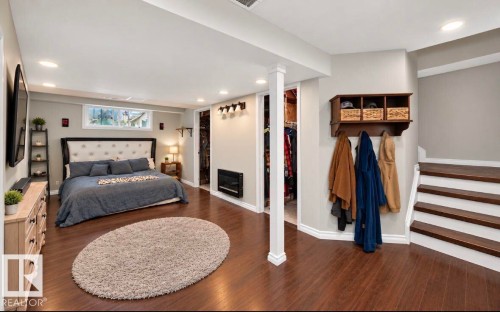 Expansive room featuring wood-finish flooring, recessed lighting, a built-in electric fireplace, and a window for natural light - 447 Songhurst Place, Leduc, AB 