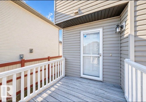 Wood-finish decking with a white railing - 447 Songhurst Place, Leduc, AB 