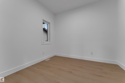 White painted walls, wood-finish flooring, and white trim - 178 Munn Way, Leduc, AB 