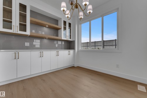 Built-in cabinetry with glass-front uppers and under-cabinet lighting - 178 Munn Way, Leduc, AB 