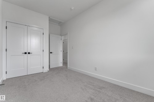 Light gray carpet flooring, white walls, white interior doors, matte black hardware, and a white ceiling - 178 Munn Way, Leduc, AB 