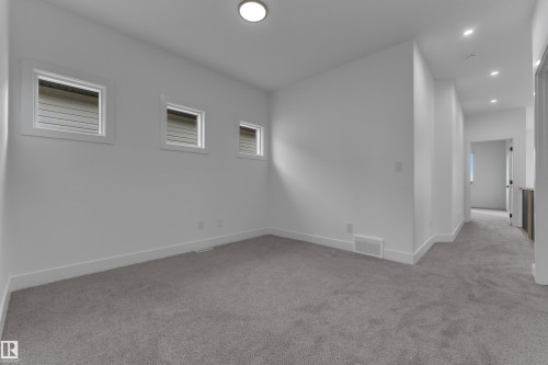 Recessed lighting, three distinct windows, and light gray carpeting - 178 Munn Way, Leduc, AB 