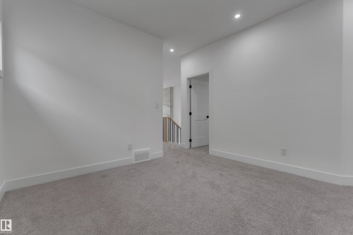 Recessed ceiling lighting, white walls, gray carpet flooring, white trim, and a white door with black hardware - 178 Munn Way, Leduc, AB 