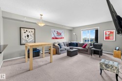 Carpeted living space with light-toned walls, recessed lighting, and a pendant light fixture - 
