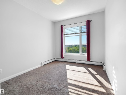 Light-colored carpeted flooring, white painted walls, and a window with blinds - #415 2588 Anderson Wy Sw, Edmonton, AB 