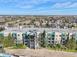 Multi-story building featuring modern exterior finishes, multiple balconies, and a prominent glass-enclosed entrance - 