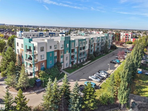 Five-story building featuring a multi-toned facade, multiple balconies, and an adjacent parking area - #415 2588 Anderson Wy Sw, Edmonton, AB 