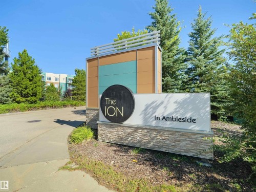 Property entrance sign featuring modern design elements, stone veneer base, and integrated landscaping - #415 2588 Anderson Wy Sw, Edmonton, AB 