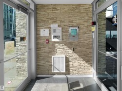 Textured stone accent wall with integrated security panel and fire alarm - 
