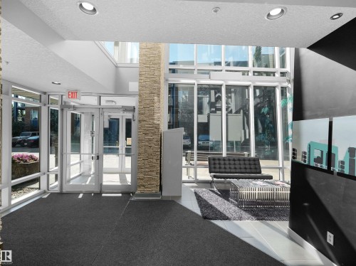 Lobby entrance with glass doors, recessed lighting, and a stone-clad column - #415 2588 Anderson Wy Sw, Edmonton, AB 